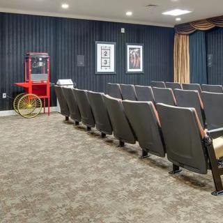 A small theater room with rows of seats and a popcorn machine.
