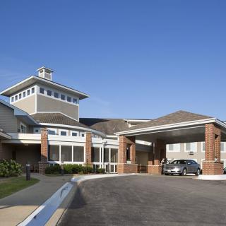 A modern building with a covered entrance and a driveway.