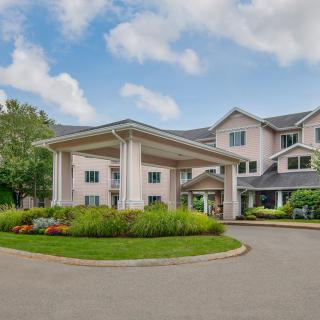 A residential building with a grand entrance and well-maintained gardens.
