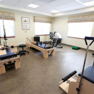 A spacious exercise room equipped with Pilates machines and workout gear.