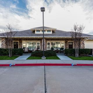 A suburban residential building with neatly landscaped front and a clear driveway.