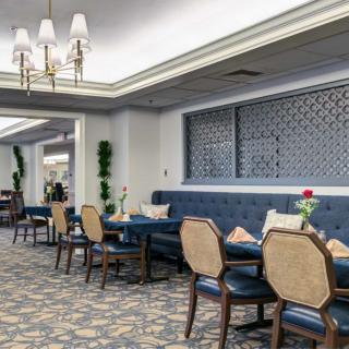 A luxurious dining area with blue upholstered seating and elegant chandeliers.