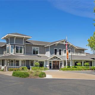 A large multi-story house with a well-maintained exterior and surrounding landscape.
