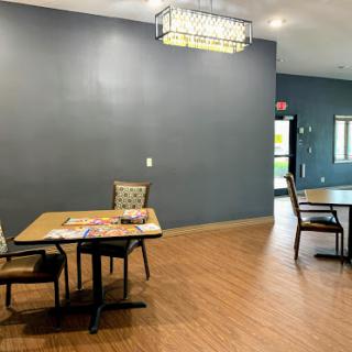 A spacious and modern dining area featuring tables and chairs with decorative lighting.