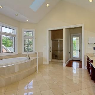 A spacious and luxurious bathroom with a large bathtub and tiled floor.