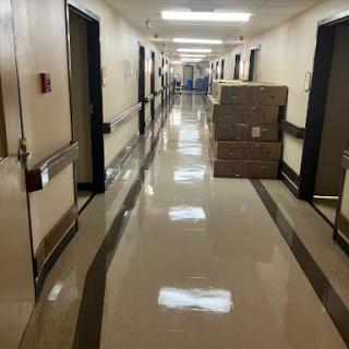 A clean and well-lit hallway with doors on either side and stacked boxes in the center.