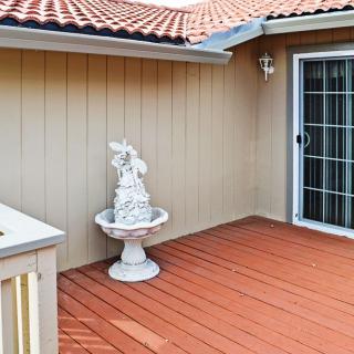 A wooden deck with a decorative fountain and sliding glass door.