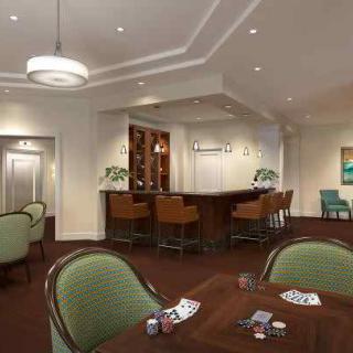 A cozy lounge area with a bar, tables set up for card games, and comfortable seating.