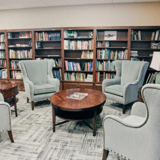 A cozy library reading area with comfortable chairs and bookshelves.