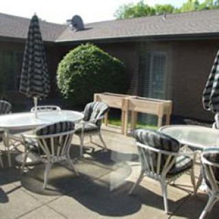 A cozy outdoor patio area with tables, chairs, and umbrellas, perfect for gatherings.