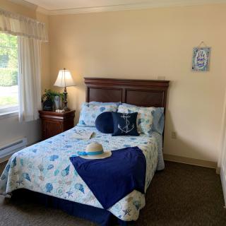 A cozy bedroom with a neatly made bed, decorative pillows, and soft lighting.