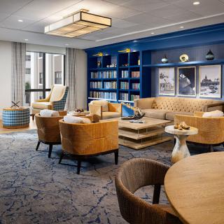 A modern living room with elegant furnishings and a blue accent wall featuring a bookcase.