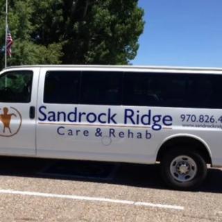 A van belonging to Sandrock Ridge Care & Rehab parked on the street.