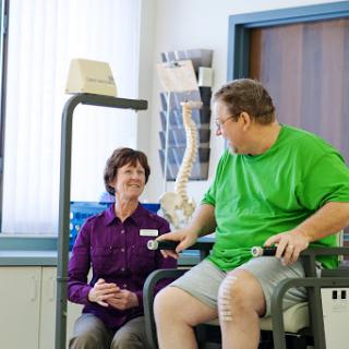 A patient engages in therapy with the assistance of a healthcare professional in a rehabilitation setting.