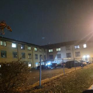 A view of an apartment complex illuminated by streetlights on a quiet night.