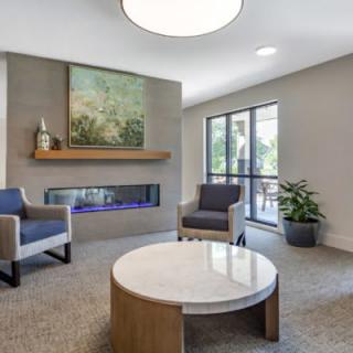 A modern living room with a fireplace, comfortable seating, and natural light.