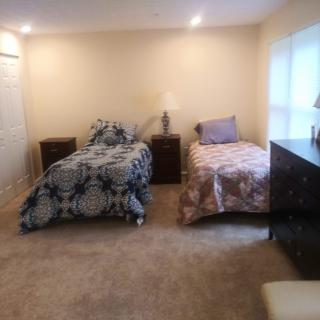 A cozy bedroom with two beds and soft lighting.