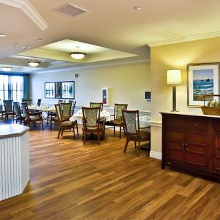A well-lit dining area with wooden flooring and elegant furnishings.