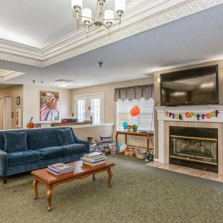 A cozy living room with a blue sofa, fireplace, and mounted television.