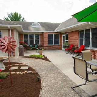 A cozy courtyard featuring a blend of seating arrangements and colorful landscaping.