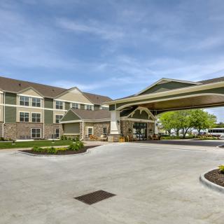 An exterior view of a hotel with a covered entrance and landscaped surroundings.