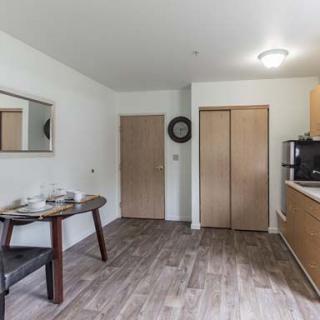 A minimalist kitchen with a wooden dining table and modern appliances.