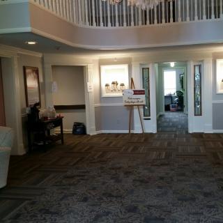 A spacious lobby area with carpeting, furniture, and a staircase.