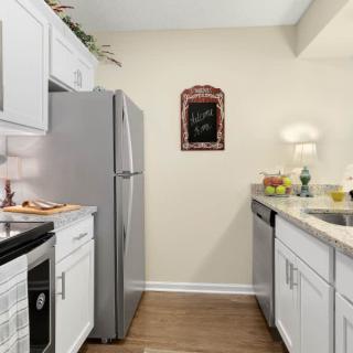 A modern kitchen with white cabinets and stainless steel appliances.