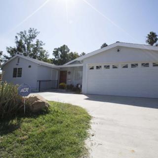 A suburban house with a driveway and garage, surrounded by trees.
