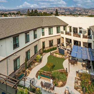 Aerial view of a modern building with a landscaped courtyard and seating areas.