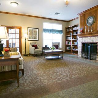 A cozy living room with a fireplace, bookshelves, and comfortable seating.