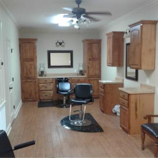 An empty hair salon with wooden cabinets and flooring.