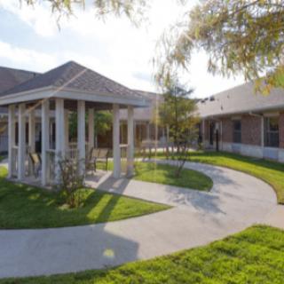 A scenic view of a building with a covered walkway and garden area.