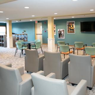 A modern lounge area with comfortable seating and a television for group meetings or relaxation.