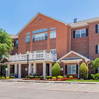 A residential brick building with a landscaped entrance.