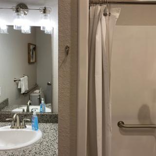 A glimpse into a neatly designed bathroom featuring a sink, mirror, and shower.