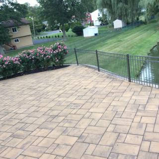 A serene outdoor patio area with flowers and a neatly maintained lawn.