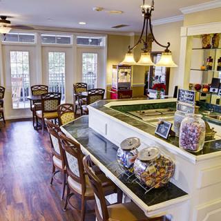A cozy cafe interior with elegant seating, decorative jars on the counter, and warm lighting.