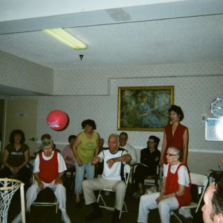 A group of seniors engaging in an indoor basketball activity at a community center.