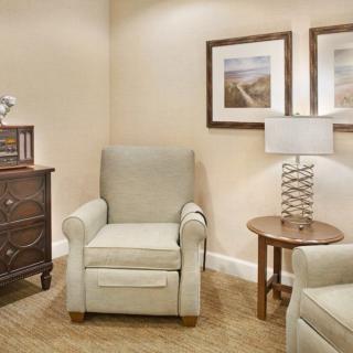 Cozy living room corner with armchairs, a side table, and artwork.