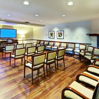 A well-designed waiting room featuring comfortable chairs and a modern television setup.