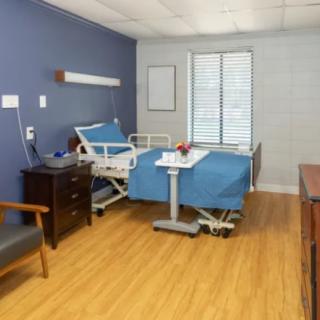 A hospital room with a medical bed and essential furniture.