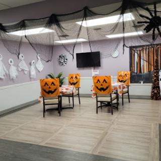 A festive Halloween-themed dining area featuring pumpkin-decorated chairs and spooky decorations.