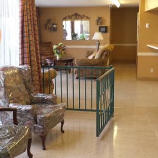A cozy living room space featuring comfortable chairs, a gated area, and warm colors.