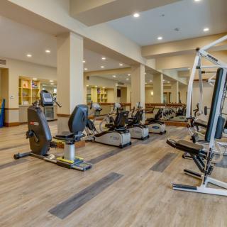 A spacious gym with various exercise machines including treadmills and stationary bikes.