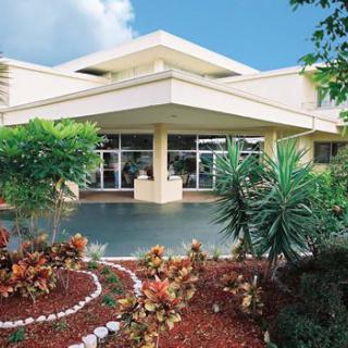 A modern building with a landscaped garden featuring various plants and shrubs.