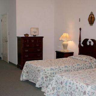 A vintage-style bedroom with twin beds and a dresser.