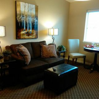 A cozy living room featuring a comfortable sofa, artistic wall decor, and warm lighting.