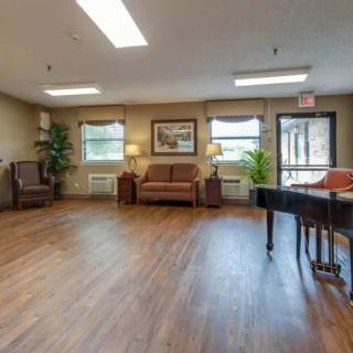 A spacious room with comfortable seating and a piano.