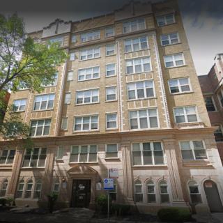 A view of a classic six-story apartment building showcasing architectural details.